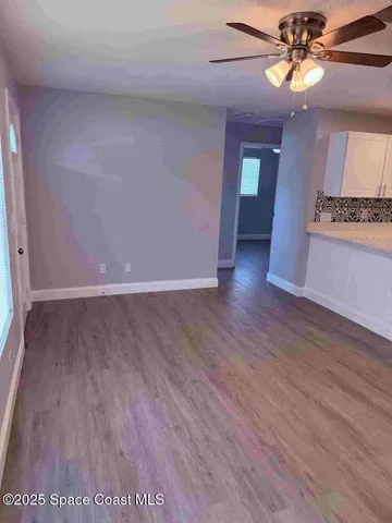 a view of an empty room and window with wooden floor