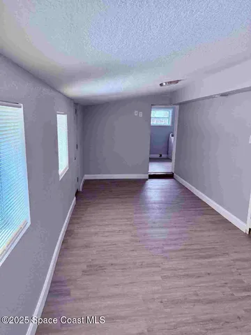 a view of a hallway with wooden floor and a window