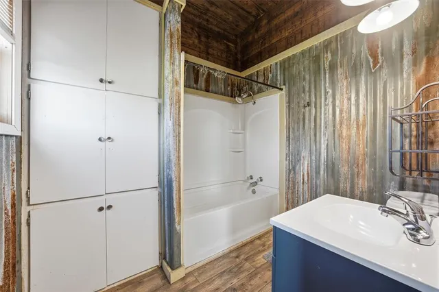 a bathroom with a sink mirror and shower