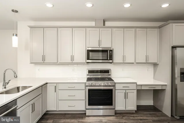 a kitchen with white cabinets and appliances