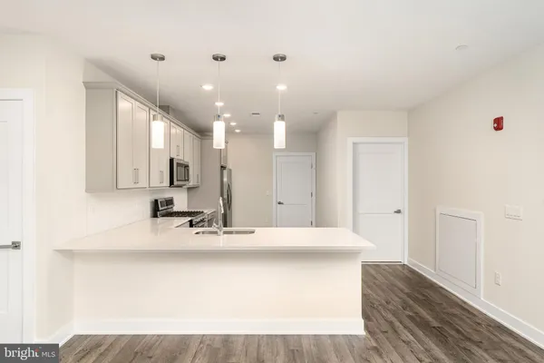 a large white kitchen with kitchen island sink stainless steel appliances and cabinets