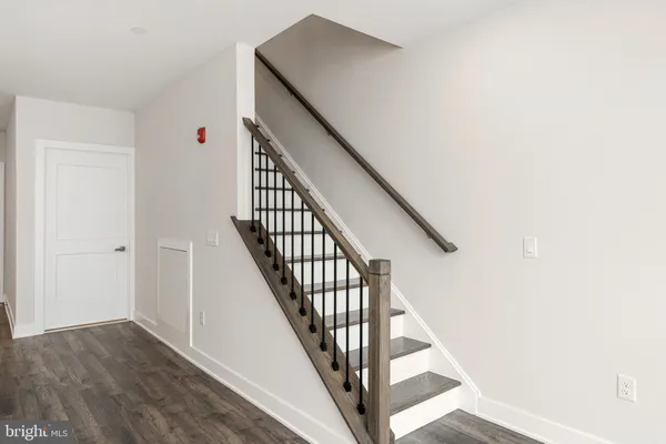a view of staircase with wooden floor and white walls