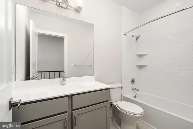 a bathroom with a sink toilet vanity and shower