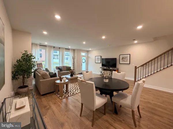 a living room with furniture a flat screen tv and a table