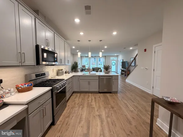 a large kitchen with stainless steel appliances granite countertop lots of counter top space a sink and cabinets