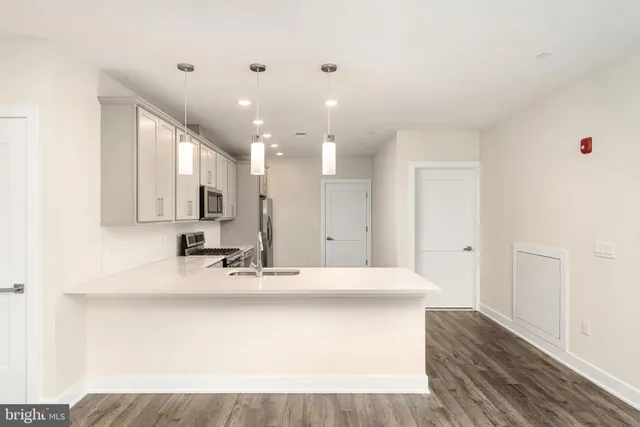 a large white kitchen with kitchen island sink stainless steel appliances and cabinets