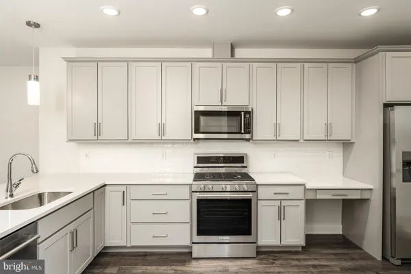 a kitchen with white cabinets and appliances