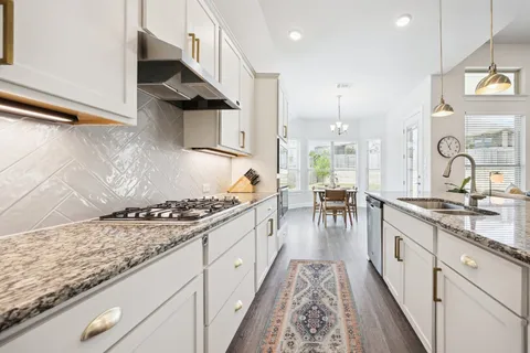 a kitchen with stainless steel appliances granite countertop a stove and a sink