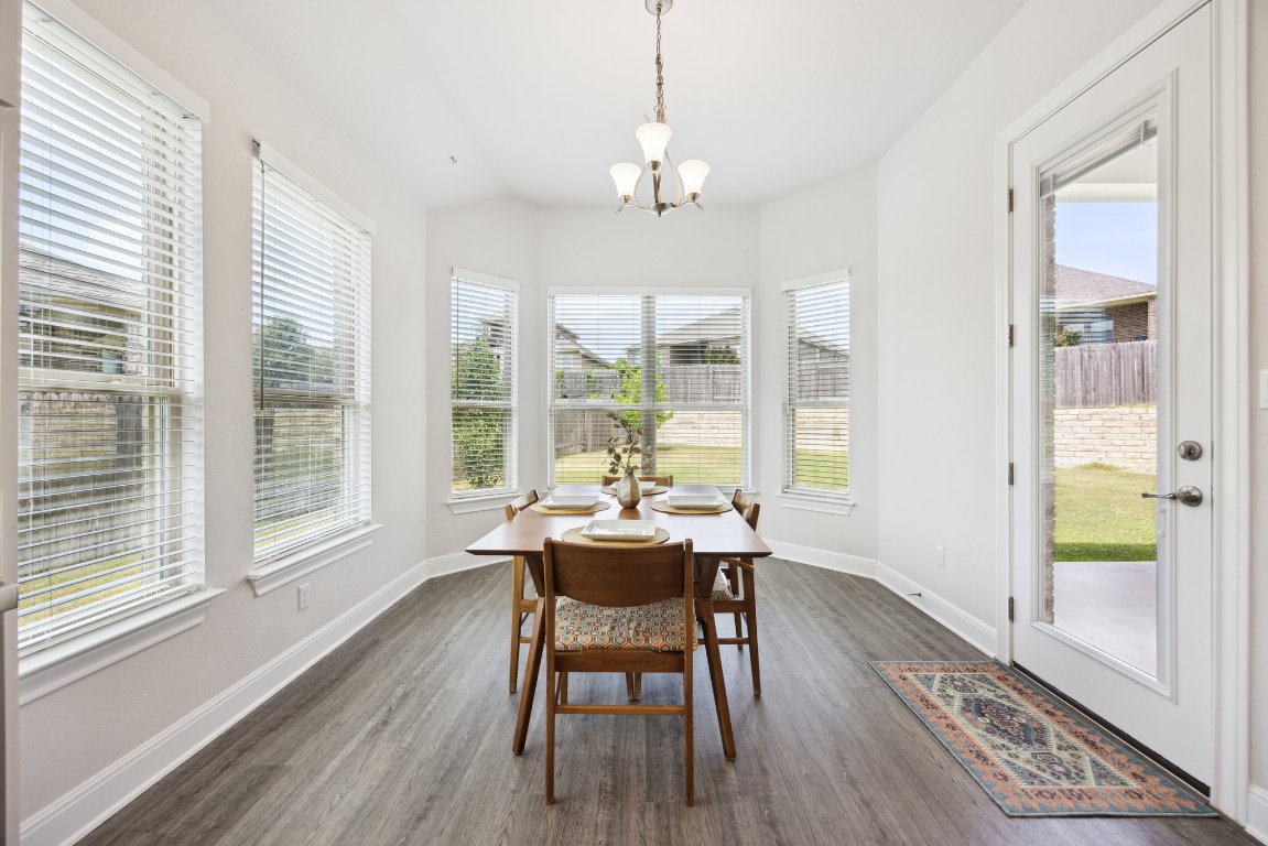 744 Founders Ridge Dripping Springs, TX 78620 - Photo 14 of 32 a dining room with wooden floor and a chandelier