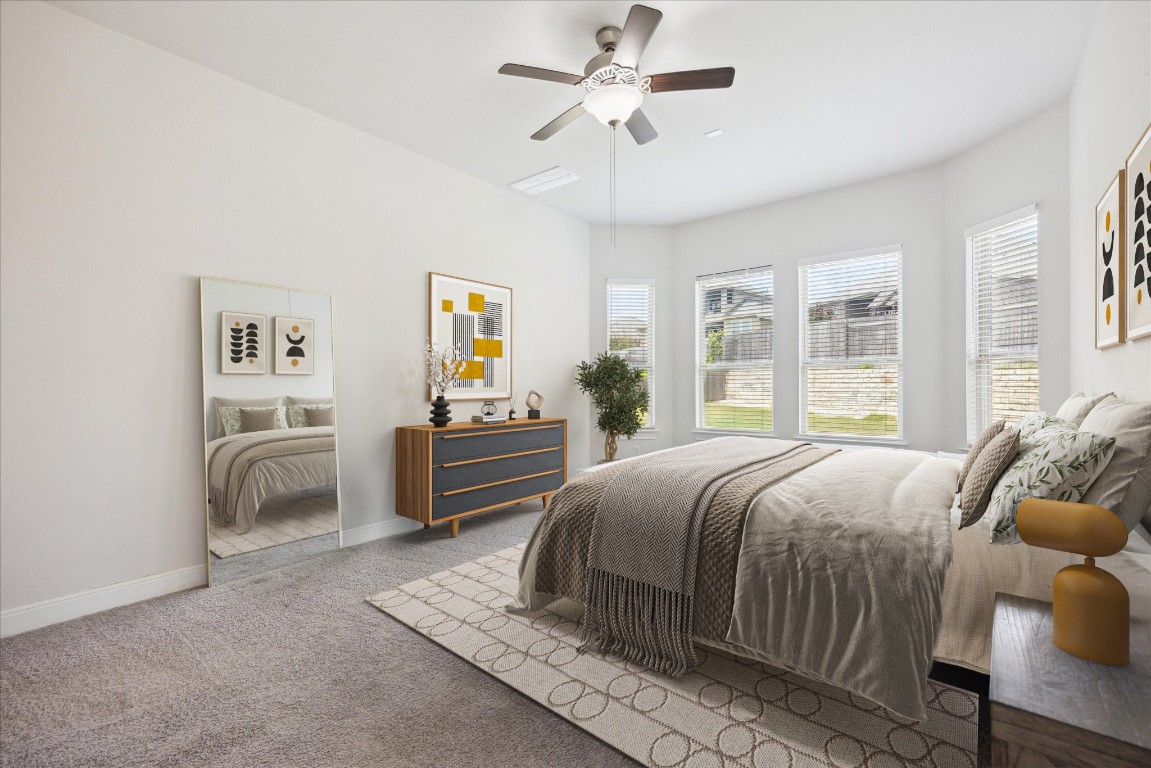744 Founders Ridge Dripping Springs, TX 78620 - Photo 18 of 32 a bedroom with a large bed and a chandelier