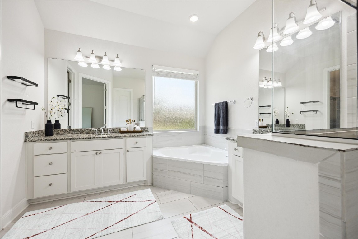 744 Founders Ridge Dripping Springs, TX 78620 - Photo 20 of 32 a spacious bathroom with a double vanity sink a mirror a bathtub and a shower