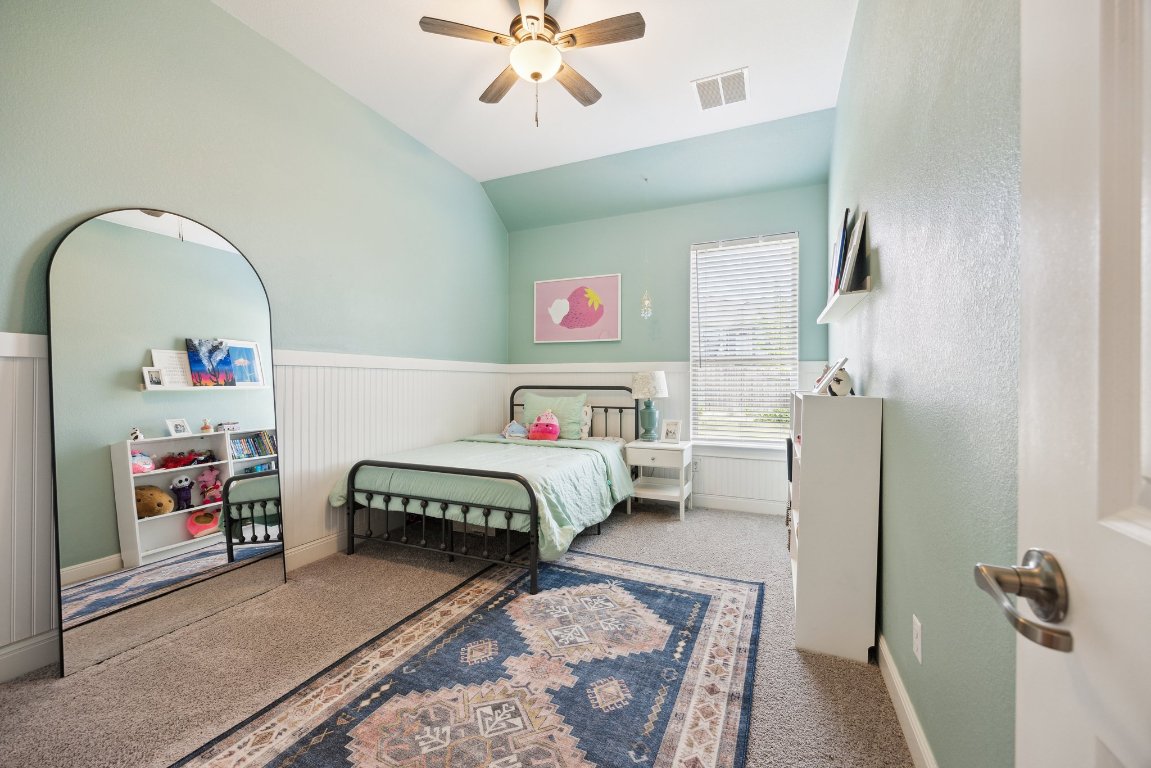 744 Founders Ridge Dripping Springs, TX 78620 - Photo 22 of 32 a bedroom with a bed and a chandelier