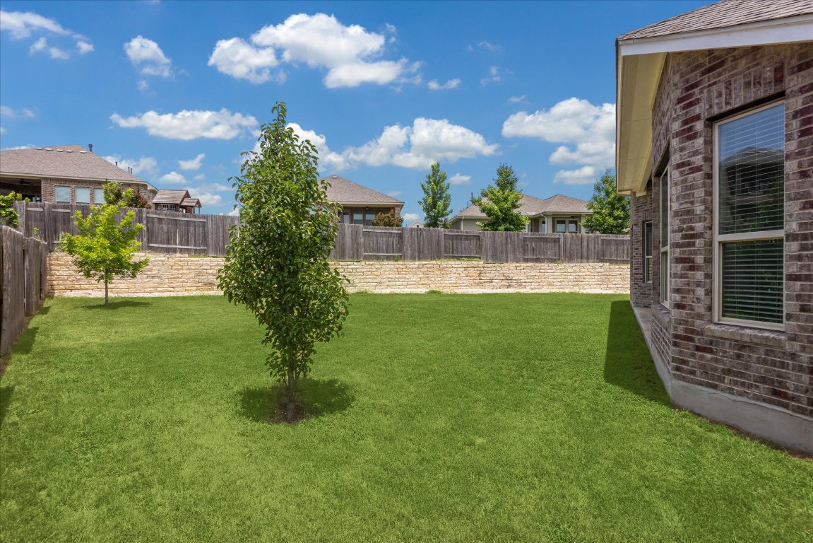 744 Founders Ridge Dripping Springs, TX 78620 - Photo 27 of 32 a view of a fountain in front of a brick house with a yard