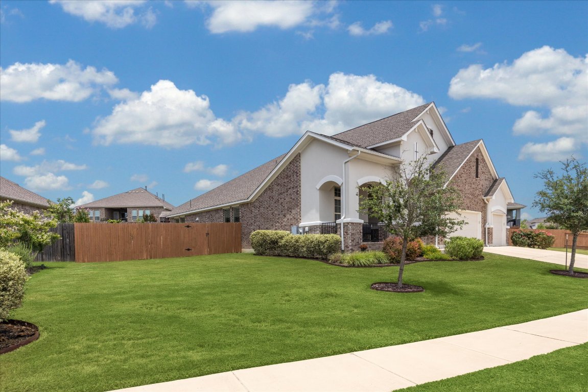 744 Founders Ridge Dripping Springs, TX 78620 - Photo 4 of 32 a front view of a house with garden and trees