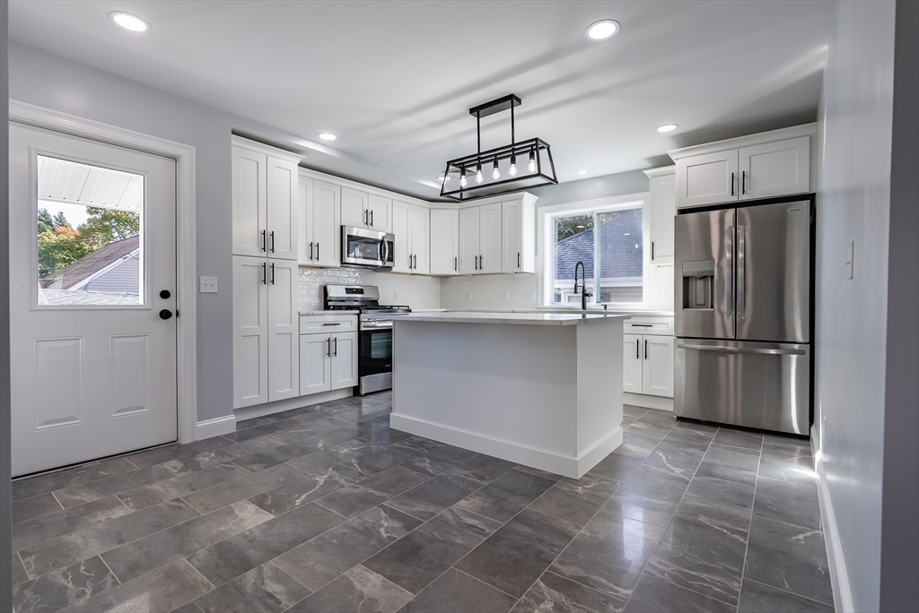 153 Ray Street Fall River, MA 02720 - Photo 4 of 29 a kitchen with stainless steel appliances a refrigerator and a stove top oven
