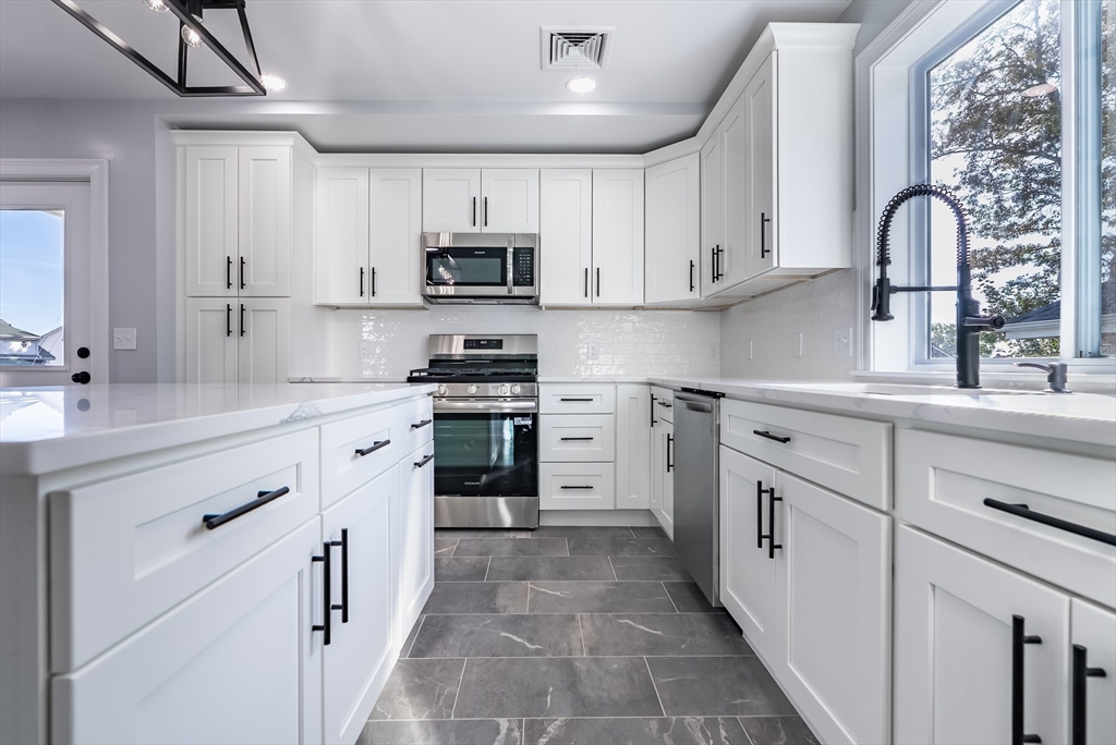 153 Ray Street Fall River, MA 02720 - Photo 6 of 29 a kitchen with stainless steel appliances granite countertop a stove sink and cabinets