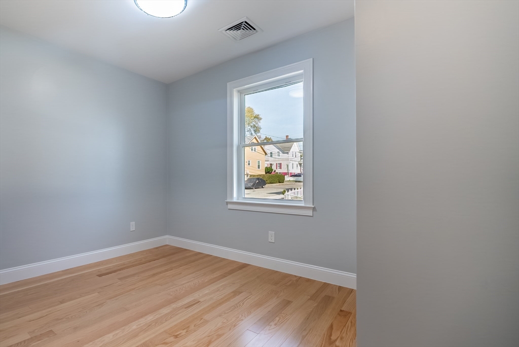 153 Ray Street Fall River, MA 02720 - Photo 9 of 29 a view of an empty room with wooden floor and a window