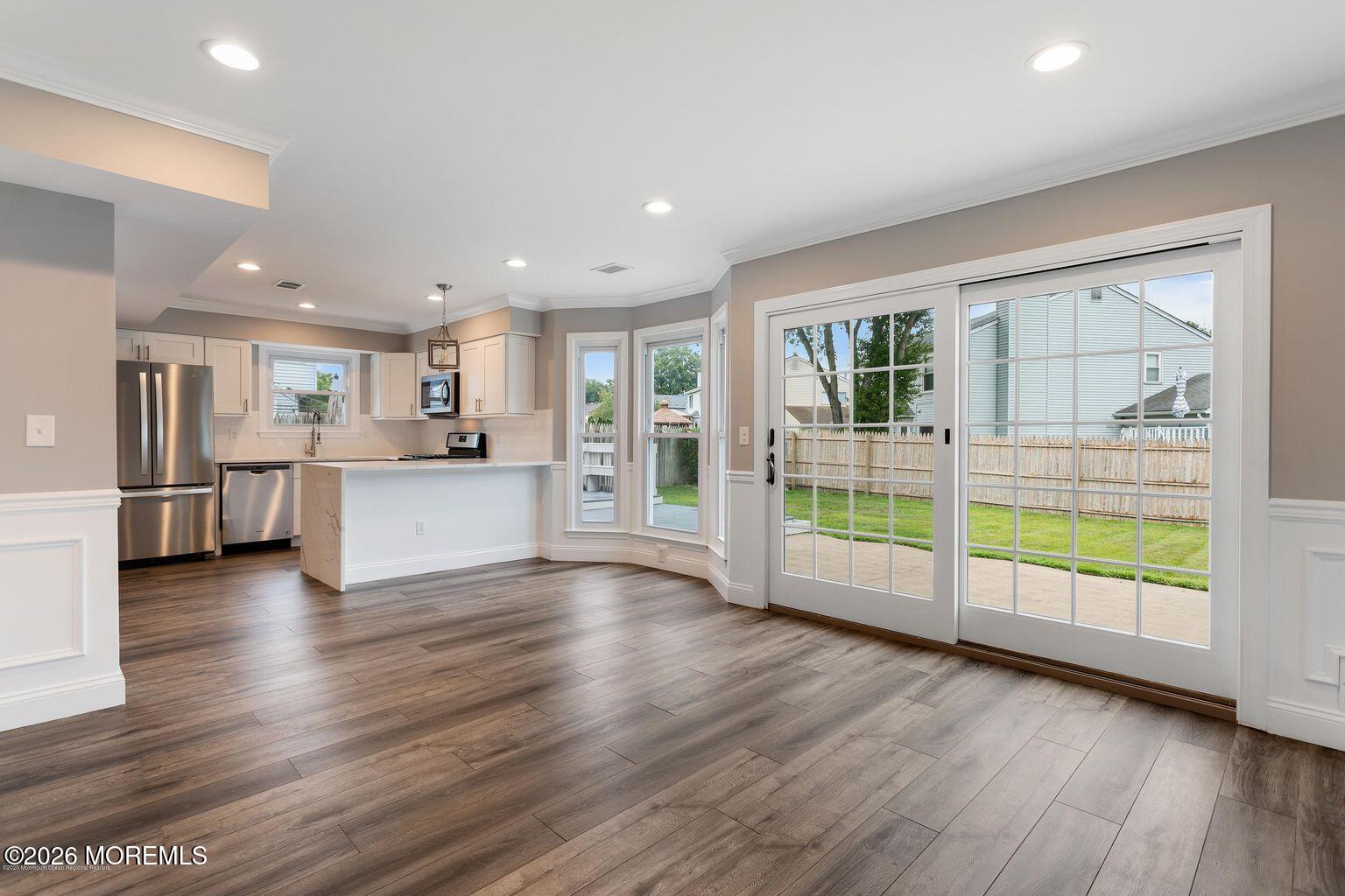 23 Sami Drive Howell, NJ 07731 - Photo 23 of 26 a view of an empty room with wooden floor and a kitchen