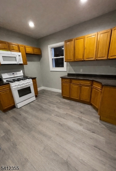 942 East 19th Street Paterson, NJ 07501 - Photo 10 of 26 a kitchen with stainless steel appliances granite countertop wooden cabinets and a stove top oven