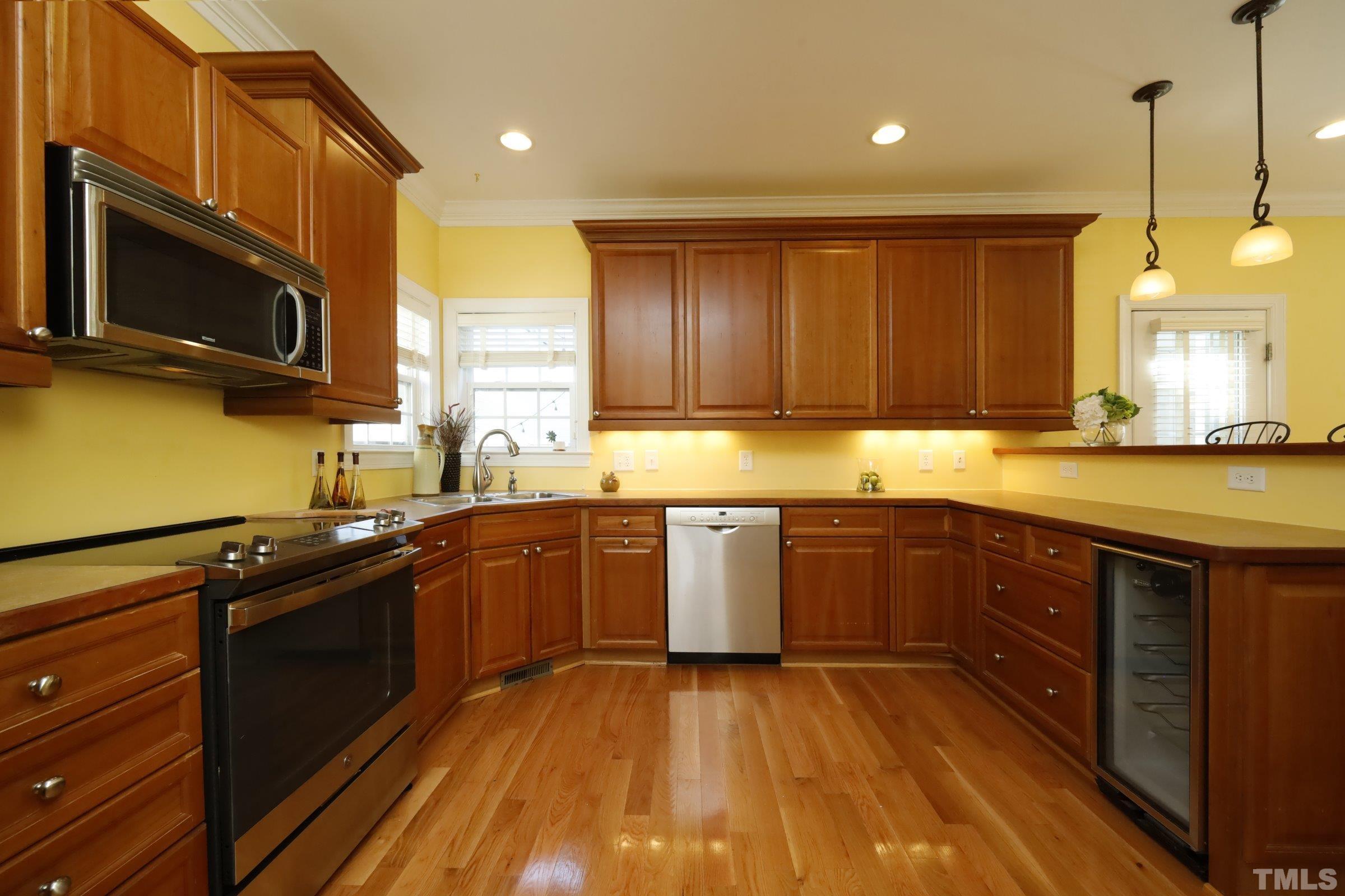 1138 Haynes Street Raleigh, NC 27604 - Photo 13 of 55 a kitchen with stainless steel appliances granite countertop wooden cabinets a stove top oven a sink and dishwasher