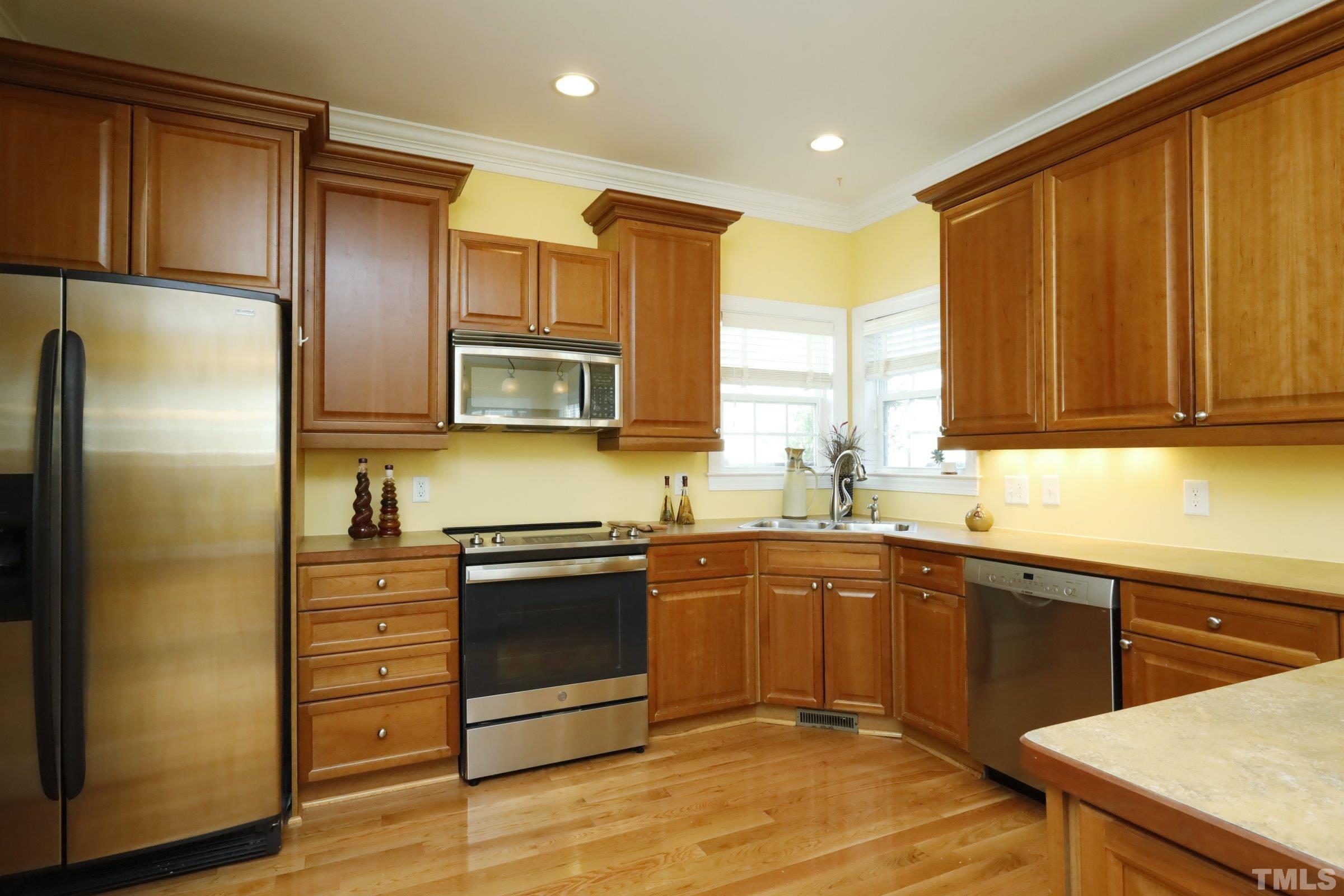 1138 Haynes Street Raleigh, NC 27604 - Photo 14 of 55 a kitchen with stainless steel appliances granite countertop wooden cabinets a refrigerator and a sink