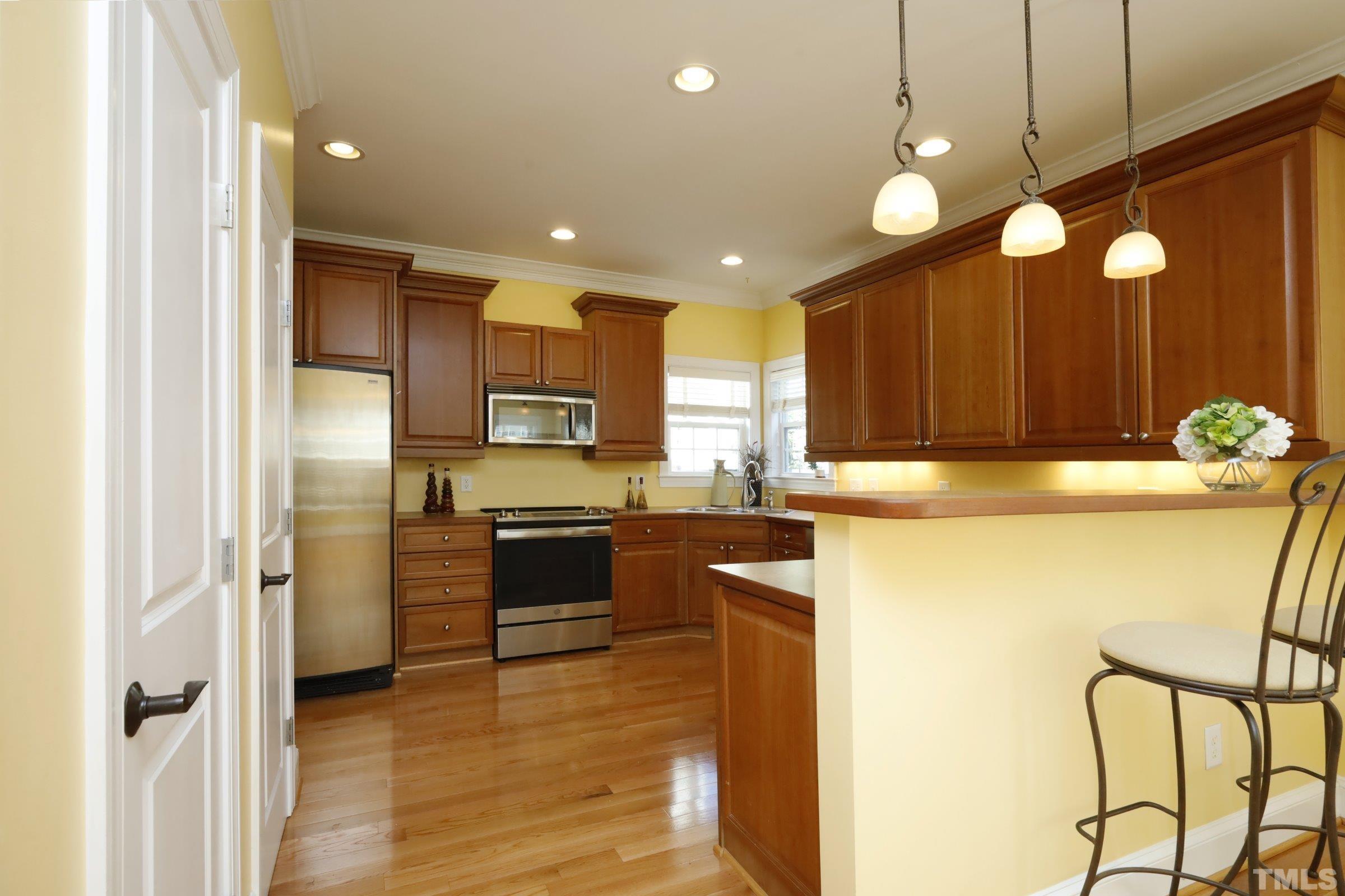 1138 Haynes Street Raleigh, NC 27604 - Photo 17 of 55 a kitchen with counter top space cabinets and stainless steel appliances