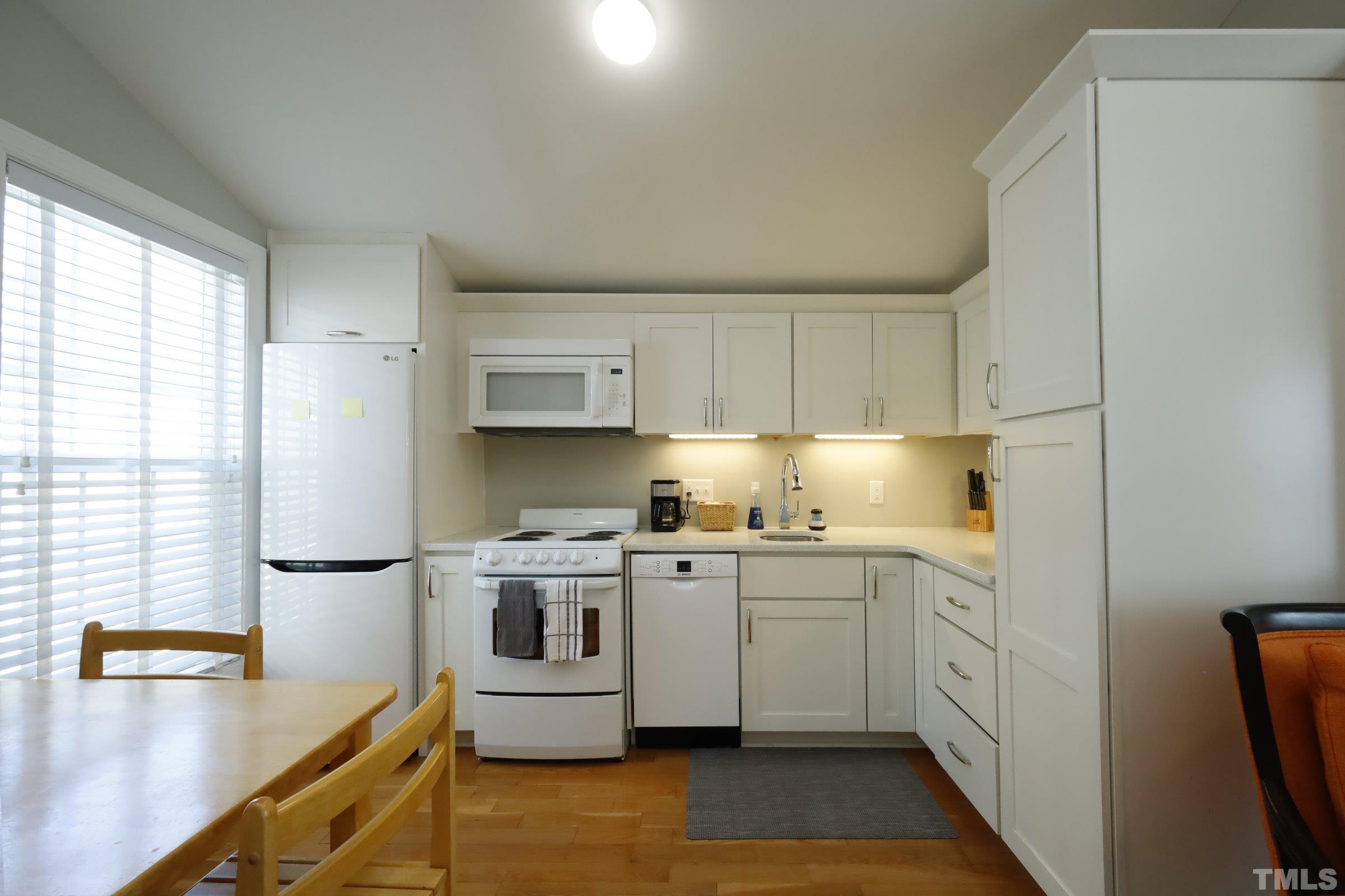 1138 Haynes Street Raleigh, NC 27604 - Photo 51 of 55 a kitchen with stainless steel appliances granite countertop a sink a stove and a refrigerator