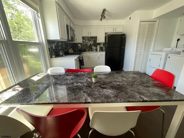 a kitchen with kitchen island a dining table and chairs