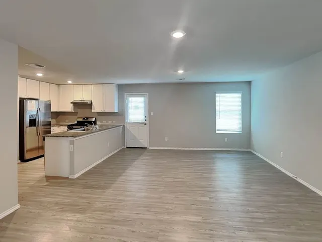 a kitchen with granite countertop a refrigerator stove and sink