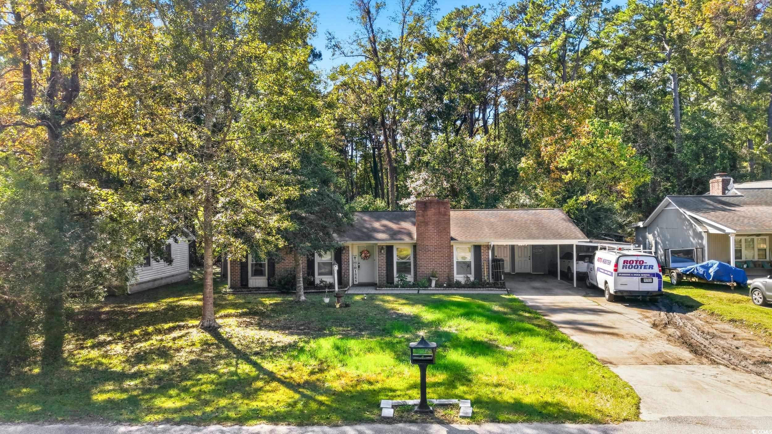 342 Red Fox Road Myrtle Beach, SC 29579 - Photo 1 of 40 View of front of home with brick siding, driveway, a front lawn, an attached carport, and covered porch