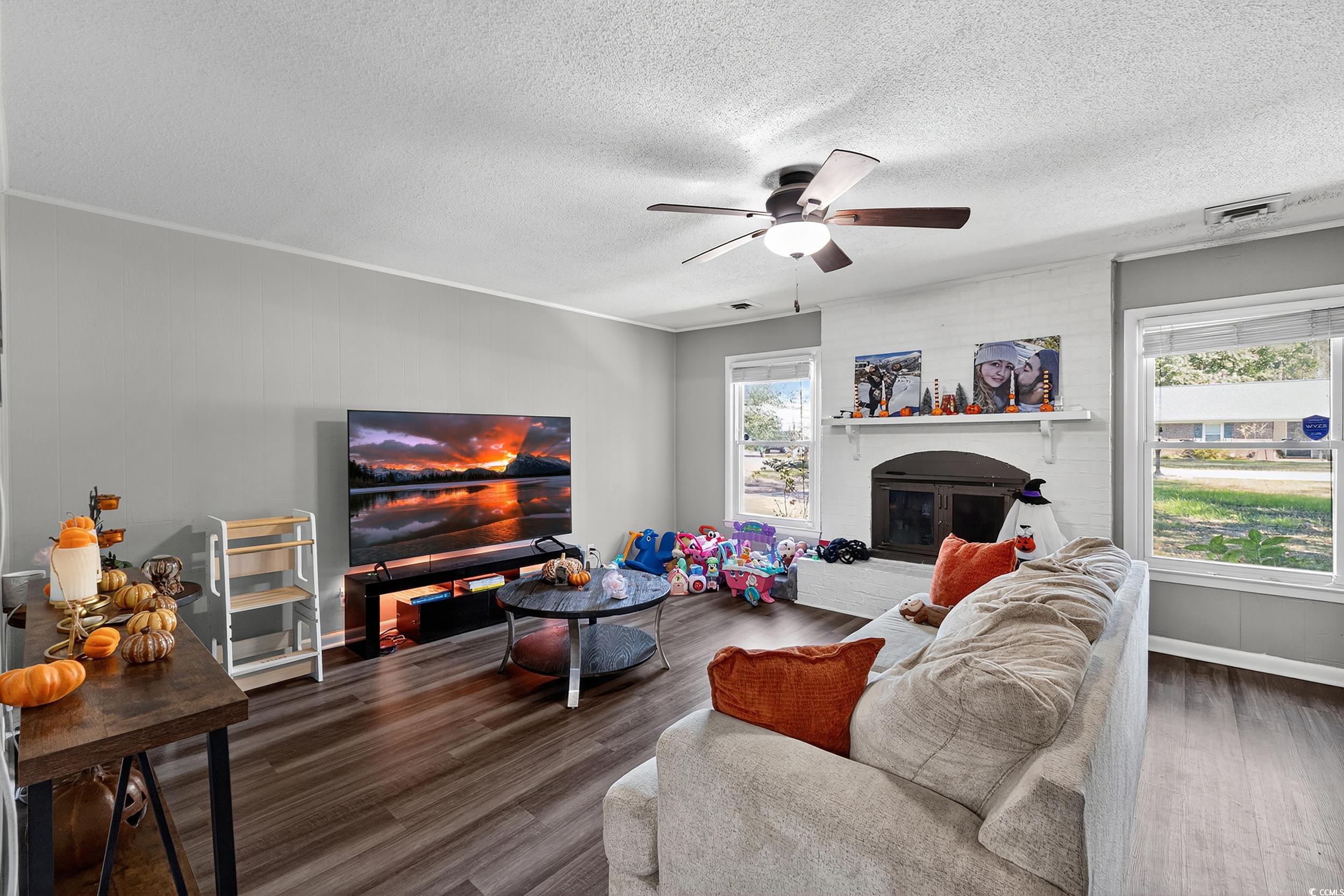 342 Red Fox Road Myrtle Beach, SC 29579 - Photo 2 of 40 Living room with a brick fireplace, dark wood finished floors, a textured ceiling, and ceiling fan