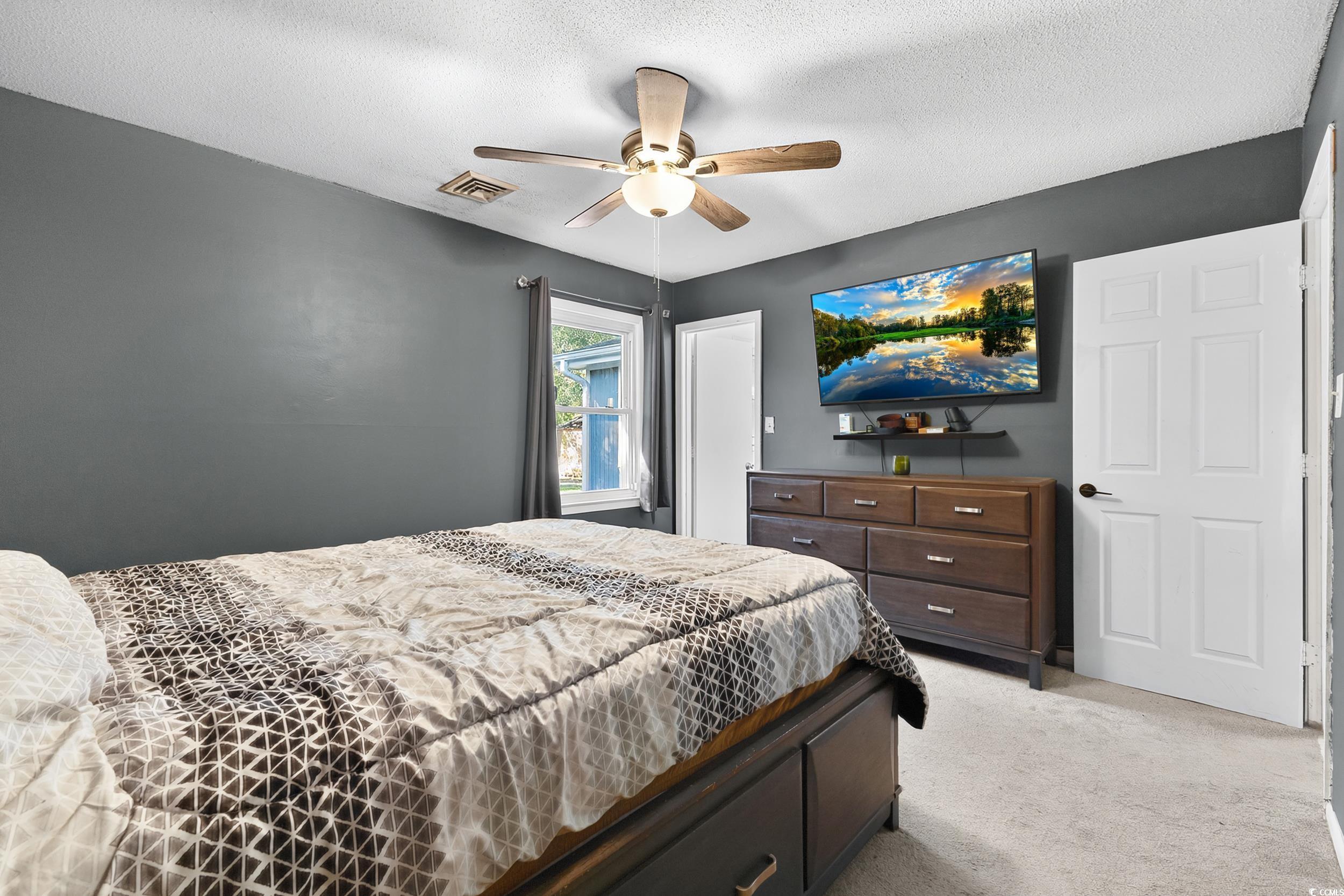 342 Red Fox Road Myrtle Beach, SC 29579 - Photo 26 of 40 Bedroom with a textured ceiling, light colored carpet, and a ceiling fan