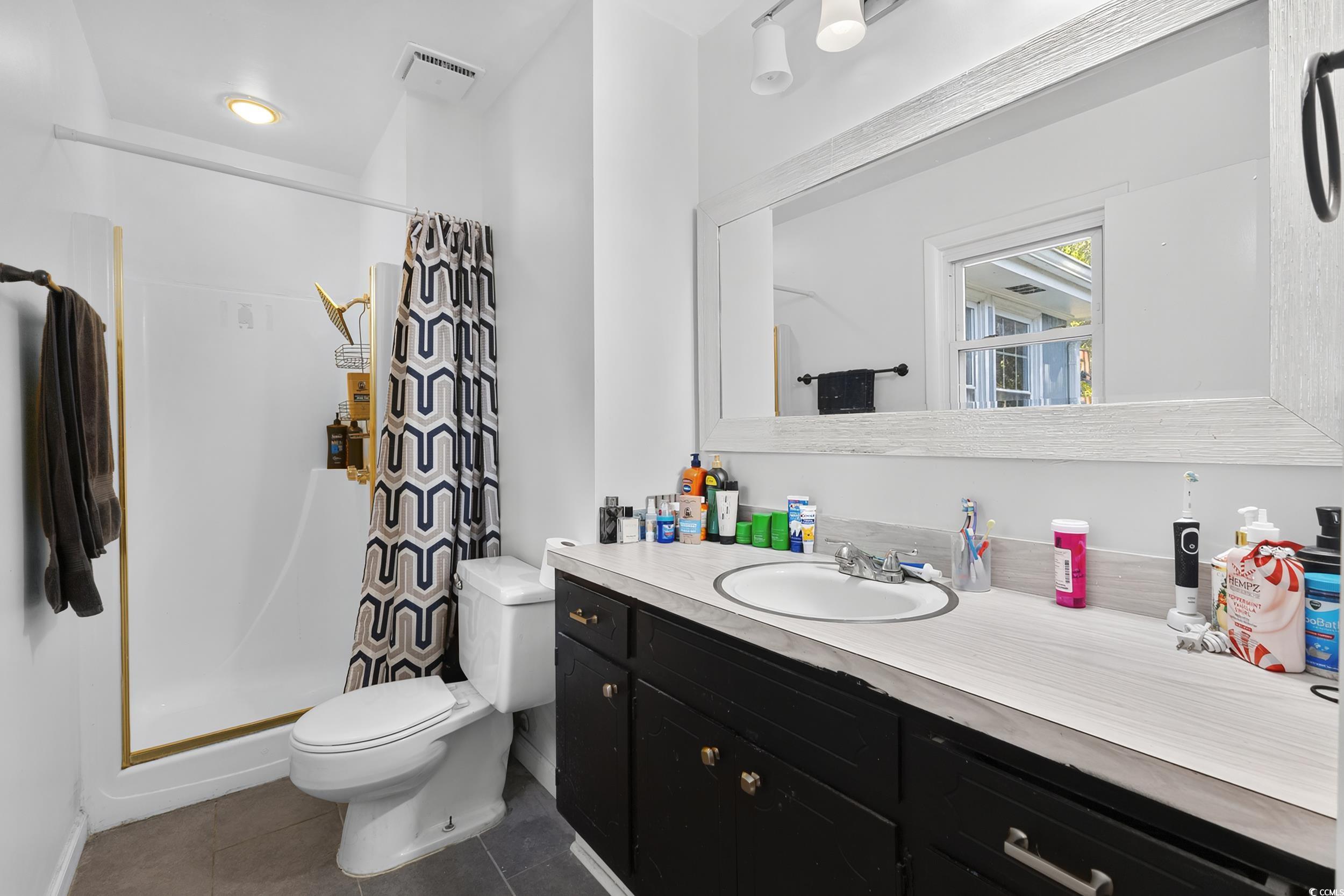 342 Red Fox Road Myrtle Beach, SC 29579 - Photo 27 of 40 Bathroom with a shower stall, vanity, and dark tile patterned floors