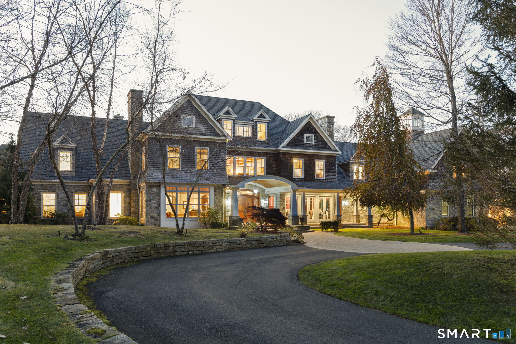 a front view of a house with a yard and trees