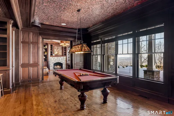 a living room with pool table and windows