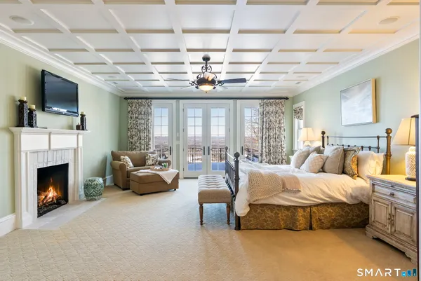 a spacious bedroom with a balcony a bed and a chandelier