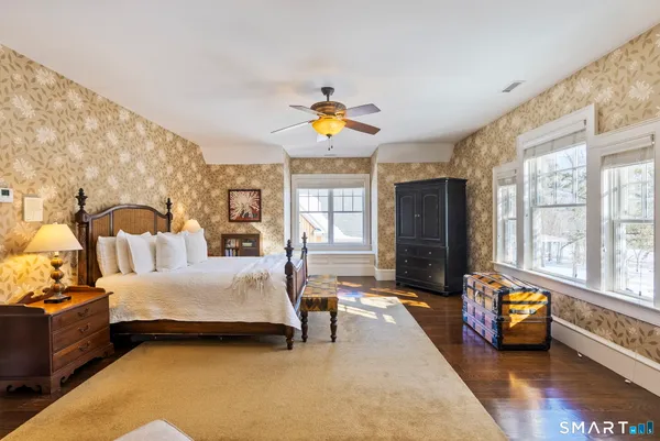 a bedroom with bed and wooden floor