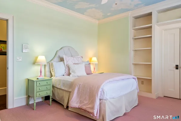 a bedroom with a bed and a lamp on dresser