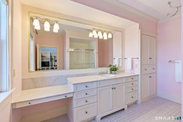 a bathroom with a granite countertop sink mirror and next to a window
