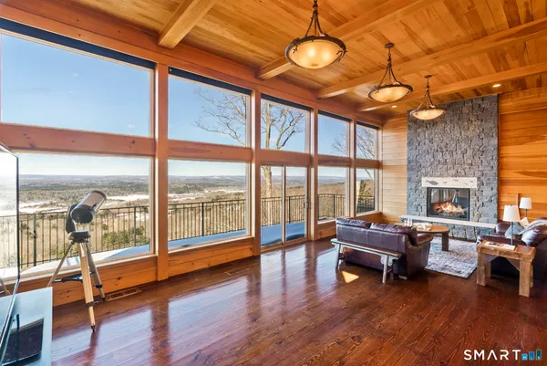 a living room with furniture a fireplace and a floor to ceiling window