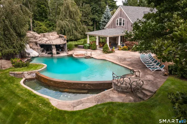an aerial view of a house with swimming pool and a yard