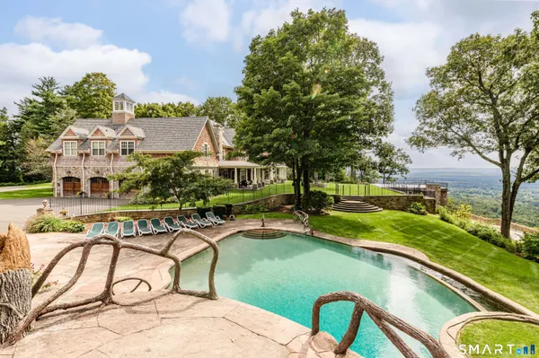 a view of a house with pool and chairs