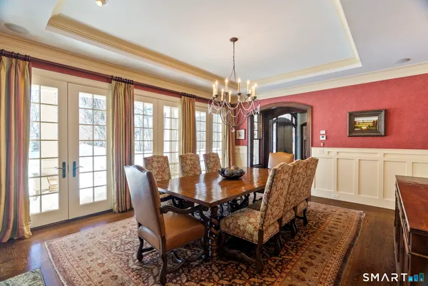 a dining room with furniture a chandelier and wooden floor