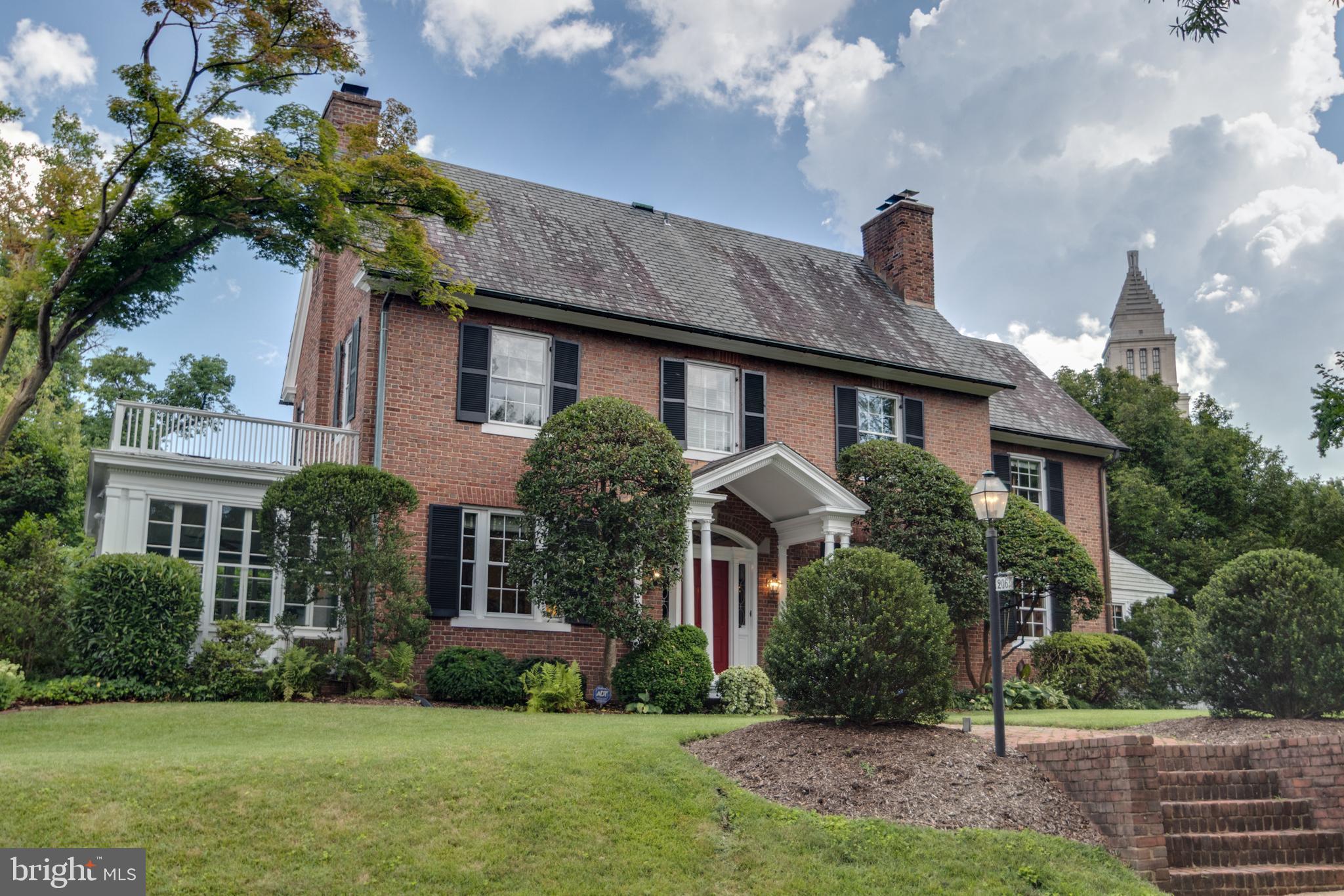 a front view of a house with a yard and potted plants
