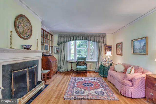 a living room with furniture a large window and a fireplace