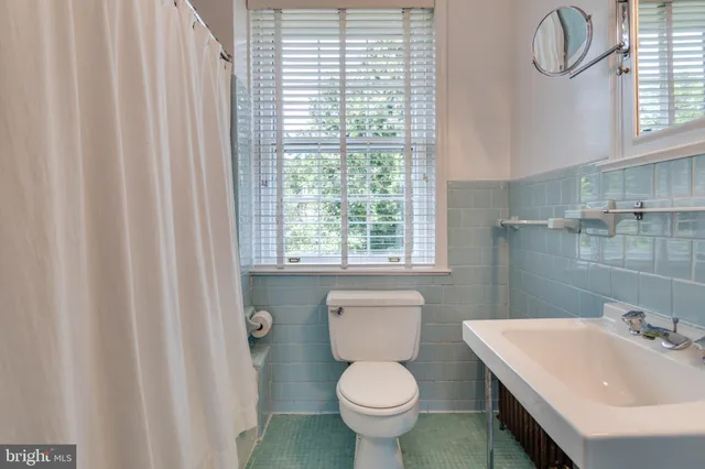 a bathroom with a sink toilet and window