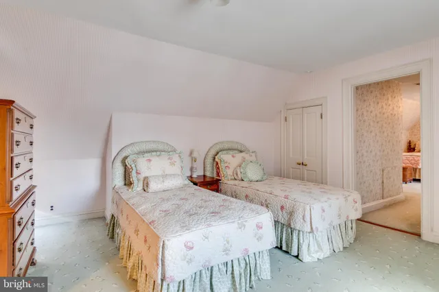 a bedroom with two beds and a dresser