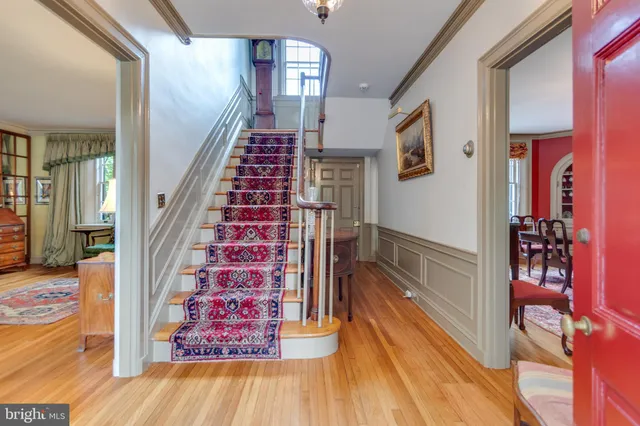 a view of a hallway with wooden floor and staircase