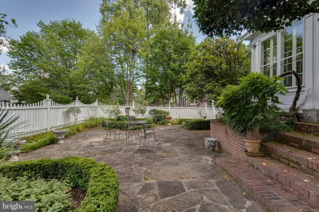 a view of backyard with a table and chairs and potted plants