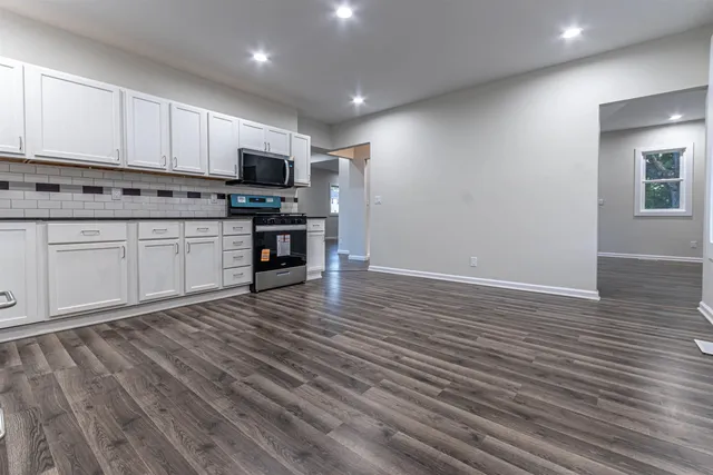 a view of a room with wooden floor and window